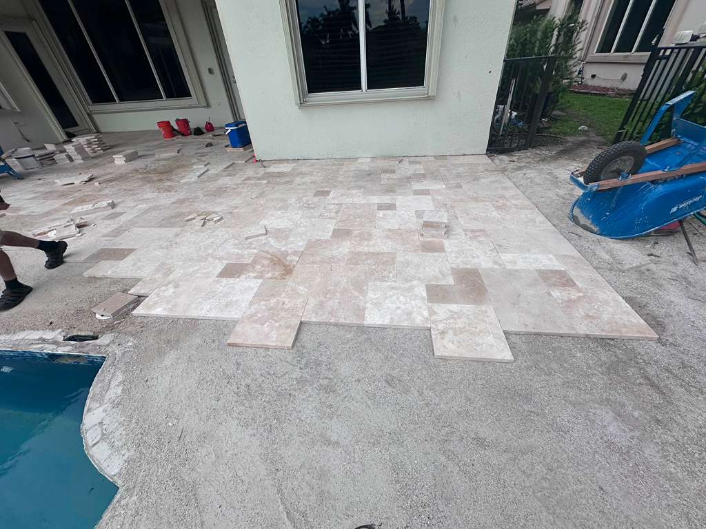Travertine pool deck and patio installation project in South Florida.
