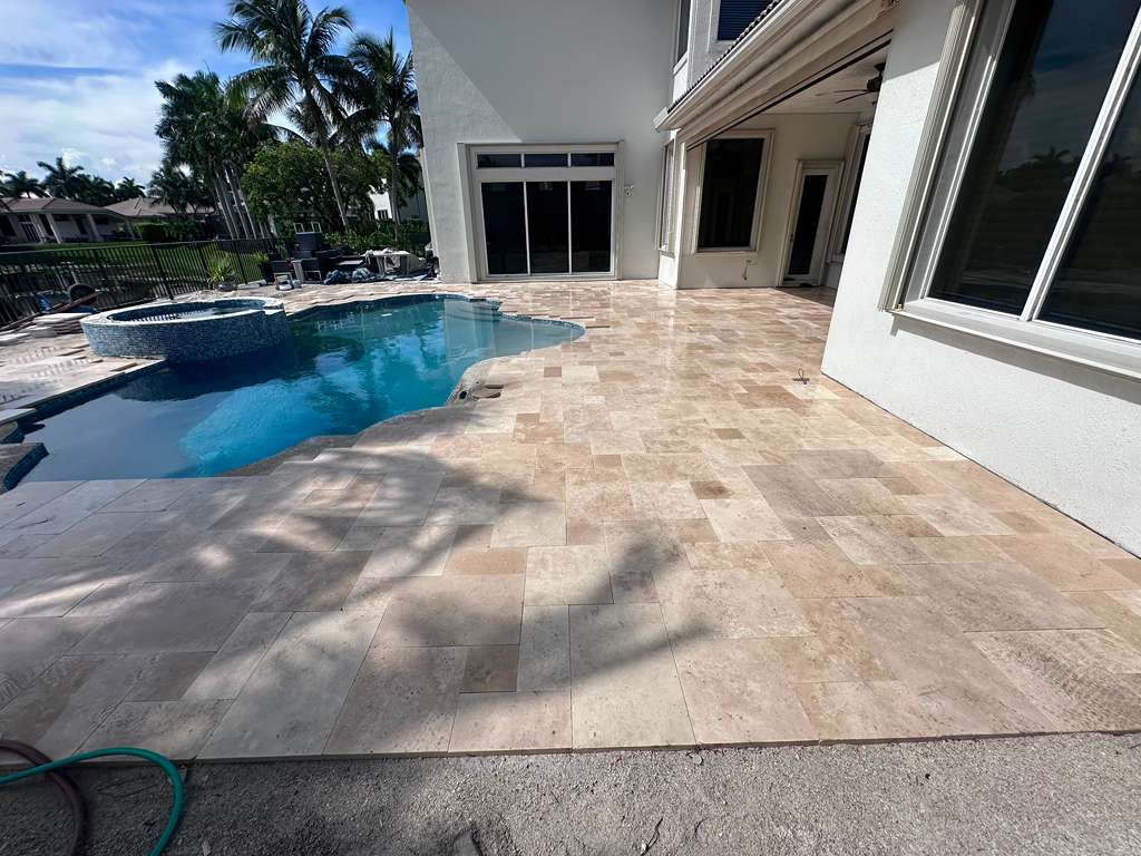 Travertine pool deck and patio installation project in South Florida.