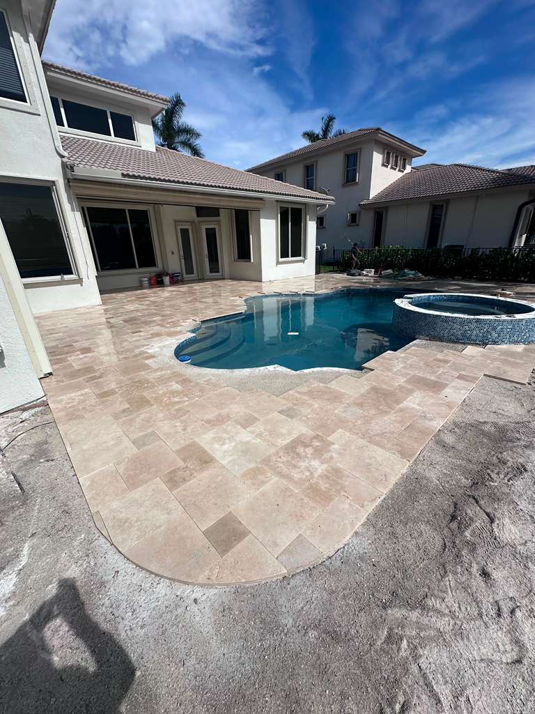 Travertine pool deck and patio installation project in South Florida.